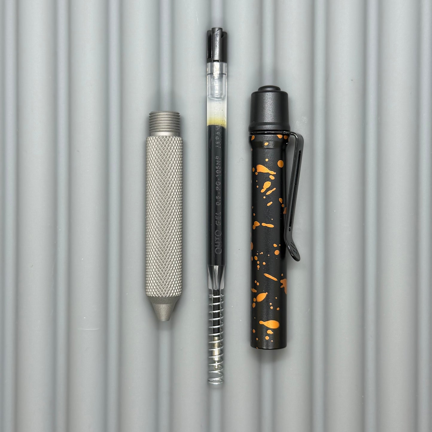 > Spoke Click Model C: Black with Orange Lava Splash, Aluminum / Matte Titanium Peak Knurled Grip